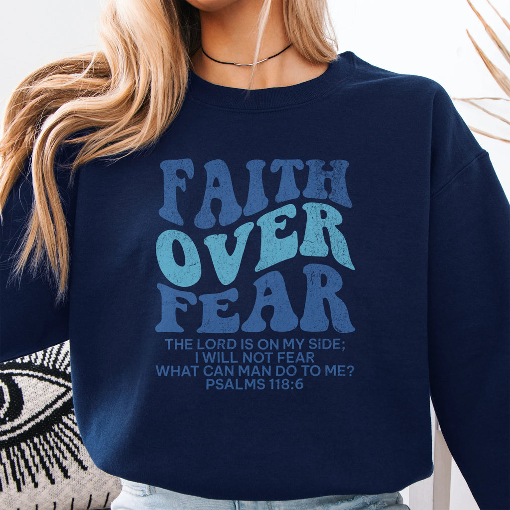 Navy Oakley June sweatshirt, large front lettering reads Faith Over Fear with supporting lines The Lord Is On My Side I Will Not Fear What Can Man Do To Me, studio front view