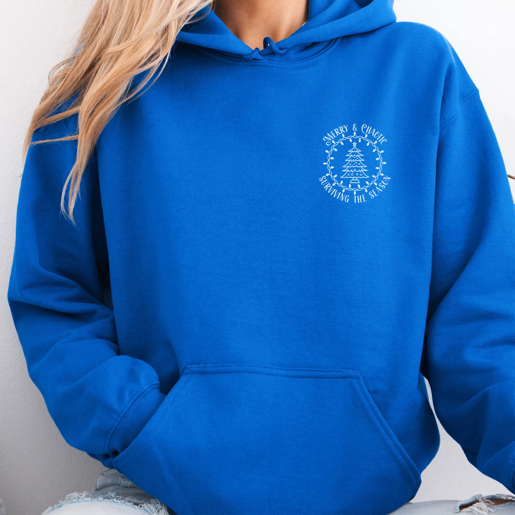 Royal women’s hoodie left chest badge text “Merry & Chaotic — Surviving the Season”