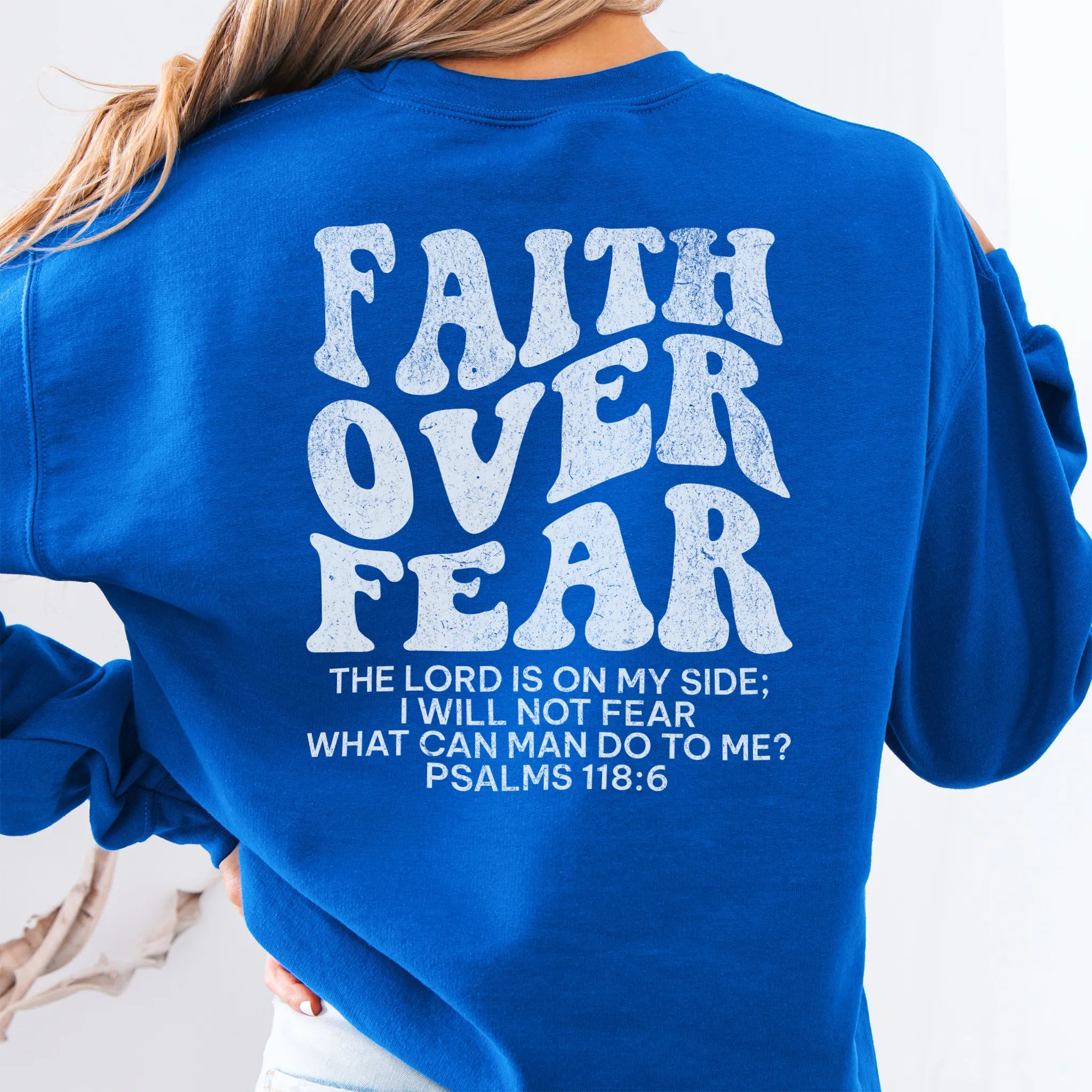 Royal Oakley June sweatshirt, large back lettering reads Faith Over Fear with supporting scripture lines, studio back view