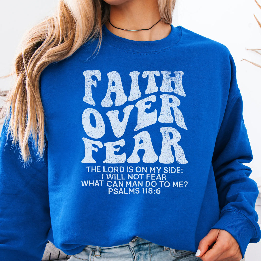 Royal Oakley June sweatshirt, large front lettering reads Faith Over Fear with supporting lines The Lord Is On My Side I Will Not Fear What Can Man Do To Me, studio front view