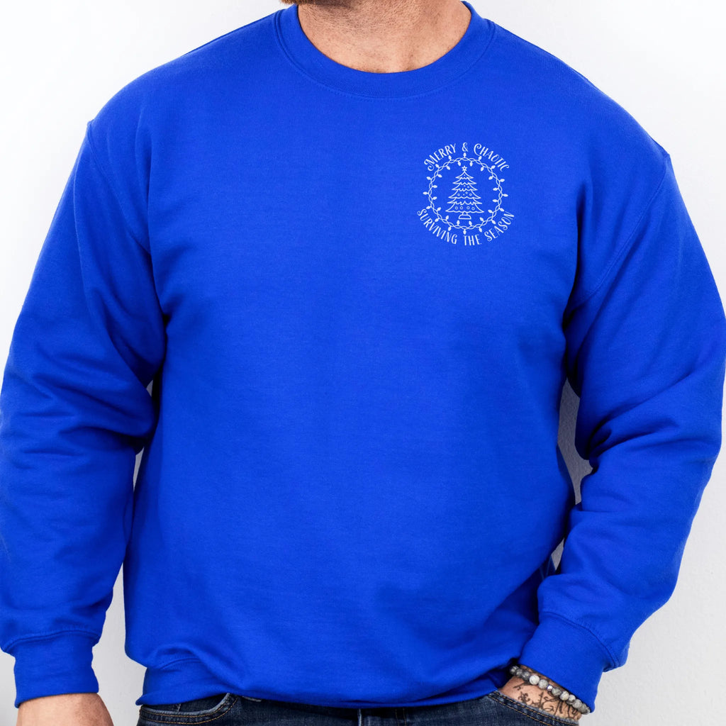 Royal men’s sweatshirt left chest badge text “Merry & Chaotic — Surviving the Season”