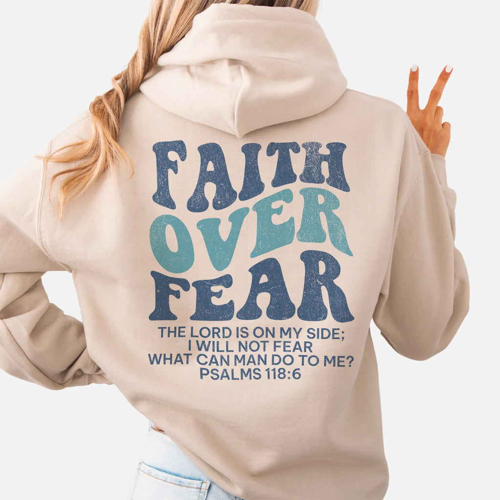 Sand Oakley June hoodie, large back lettering reads Faith Over Fear with supporting scripture lines, hood up, studio back view