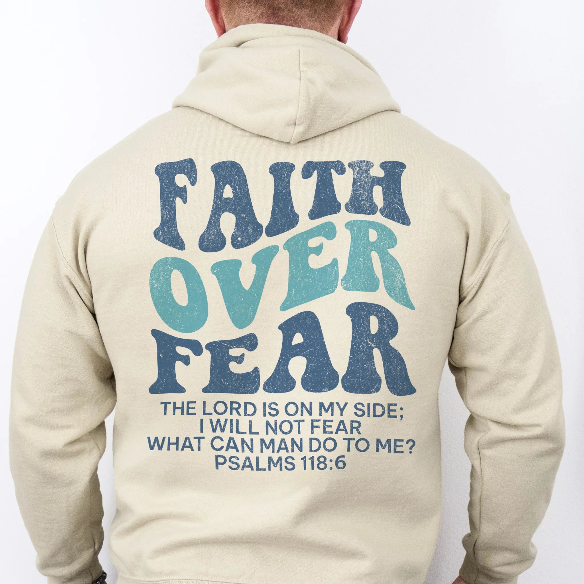 Sand Oakley June hoodie, mens fit, large back lettering reads Faith Over Fear with supporting scripture lines, hood up, studio back view