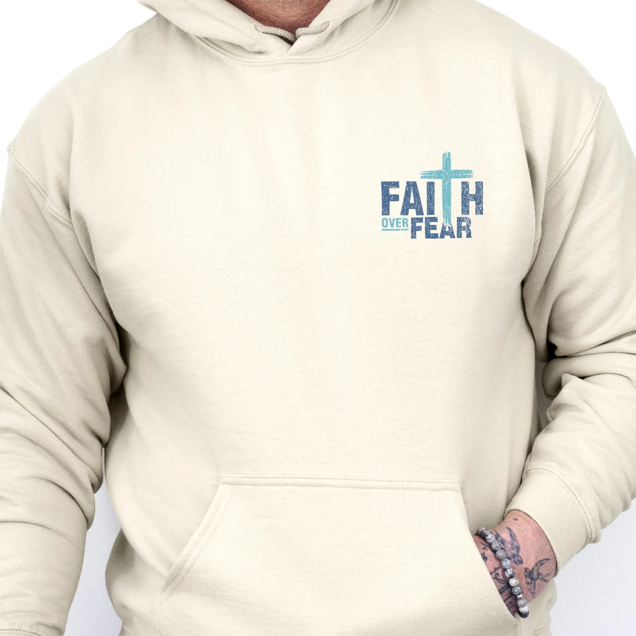 Sand Oakley June hoodie, mens fit, left chest badge reads Faith Over Fear with cross, kangaroo pocket and relaxed modern fit, studio front view