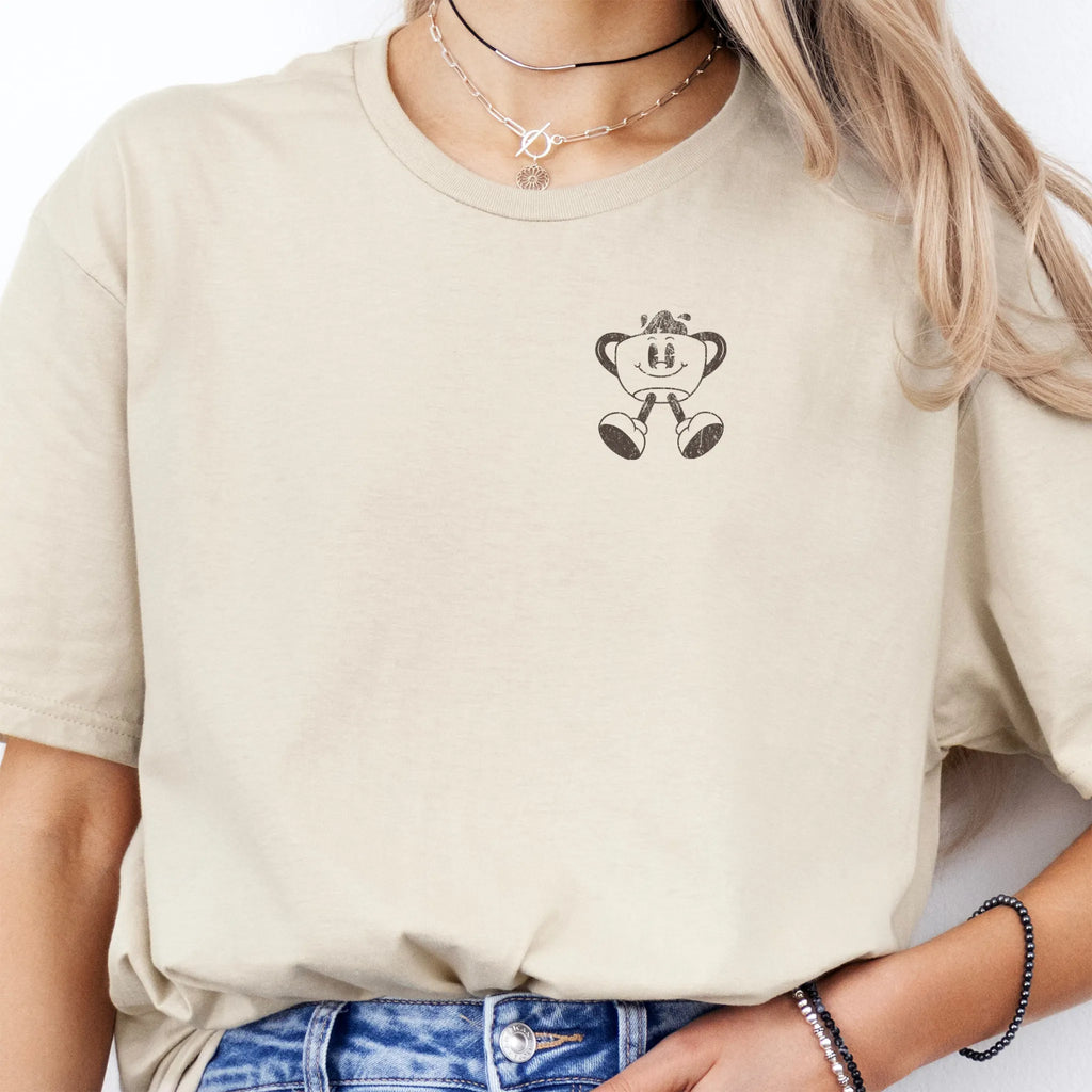 Sand Oakley June T Shirt front view small left chest coffee cup mascot Caffeinated Moms Club minimal ink distressed detail