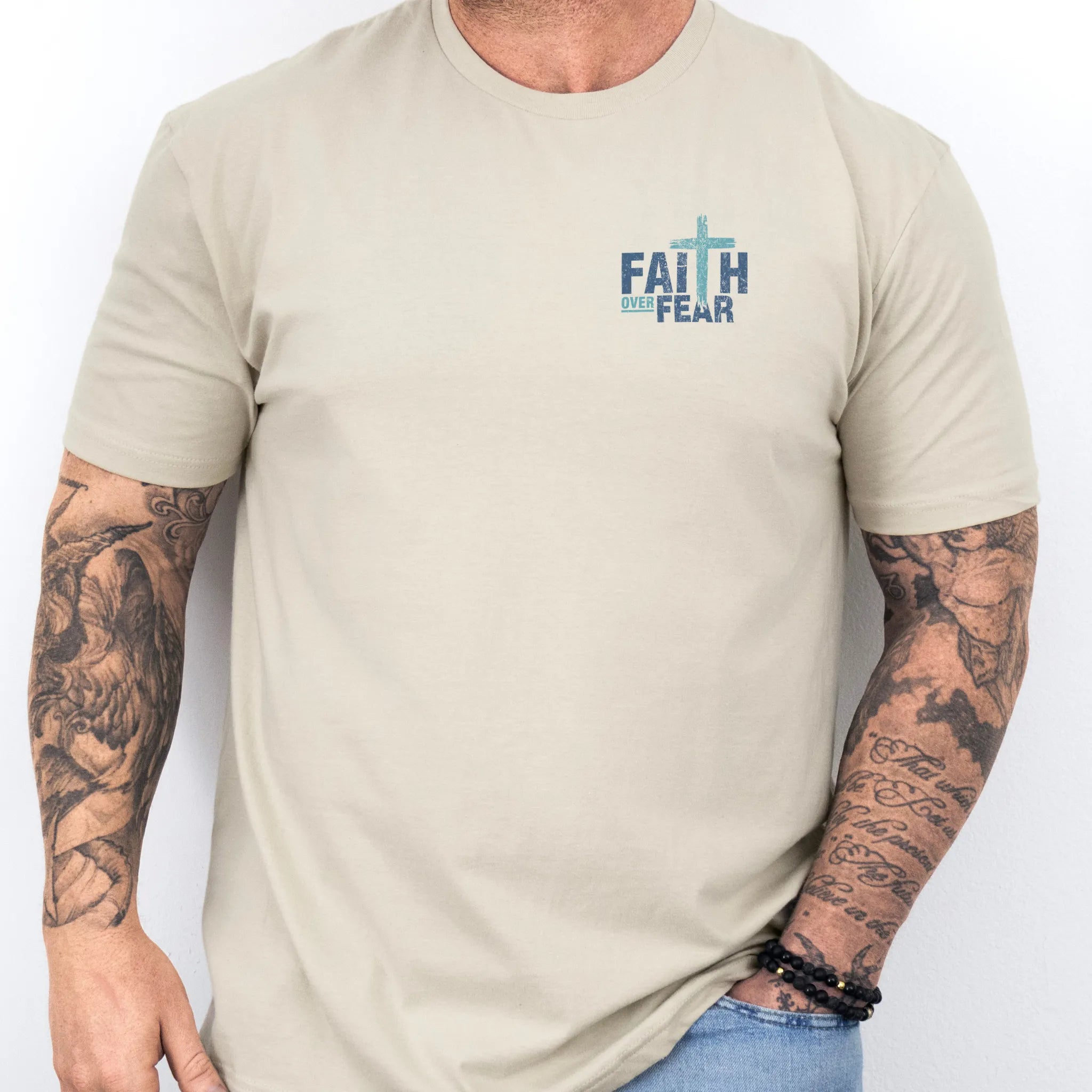 Sand Oakley June t shirt, mens fit, left chest badge reads Faith Over Fear with small cross, studio front view