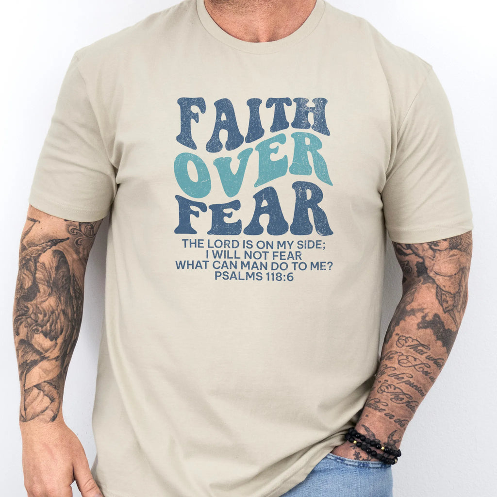 Sand Oakley June t shirt, mens fit, large front lettering reads Faith Over Fear with supporting lines The Lord Is On My Side I Will Not Fear What Can Man Do To Me, studio front view