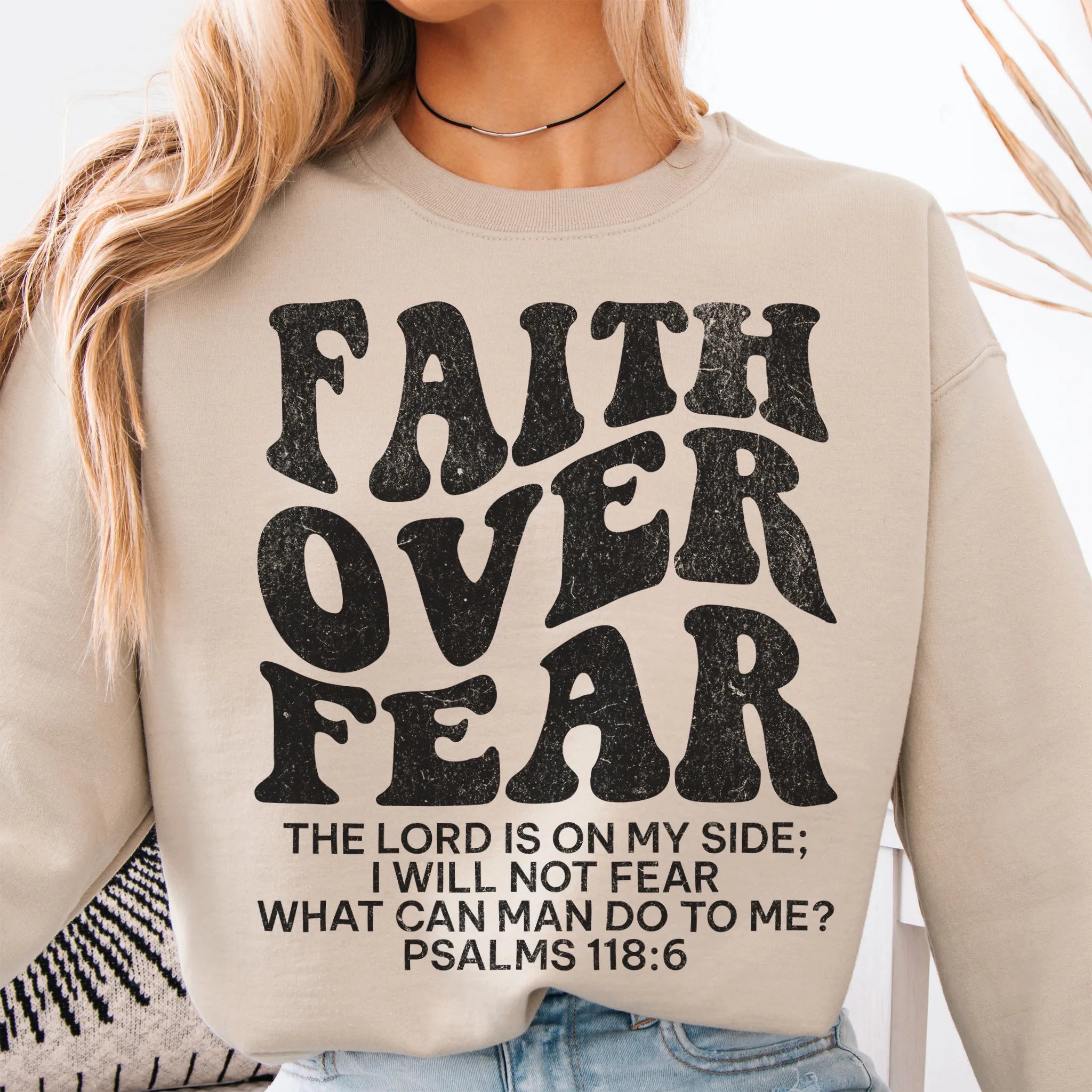 Sand Oakley June sweatshirt, large front lettering reads Faith Over Fear with supporting lines The Lord Is On My Side I Will Not Fear What Can Man Do To Me, studio front view