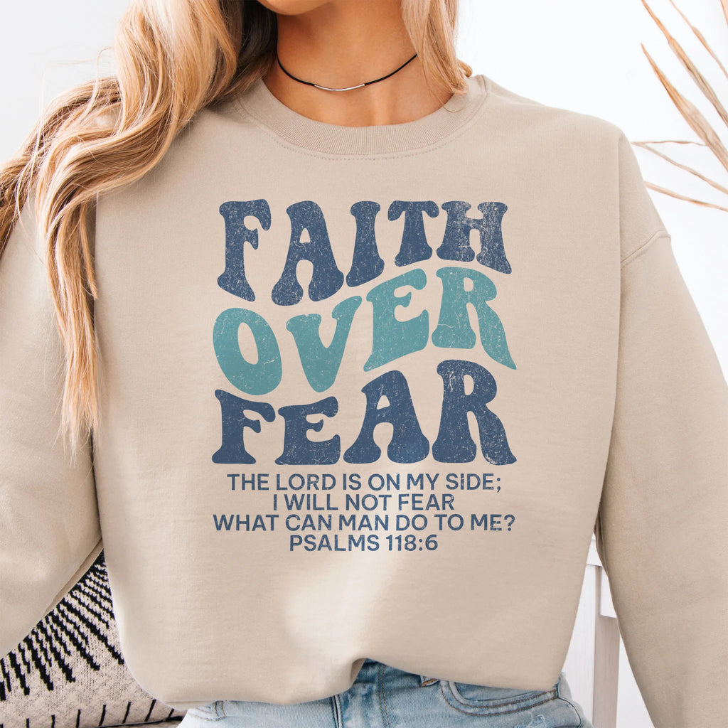 Sand Oakley June sweatshirt, large front lettering reads Faith Over Fear with supporting lines The Lord Is On My Side I Will Not Fear What Can Man Do To Me, studio front view
