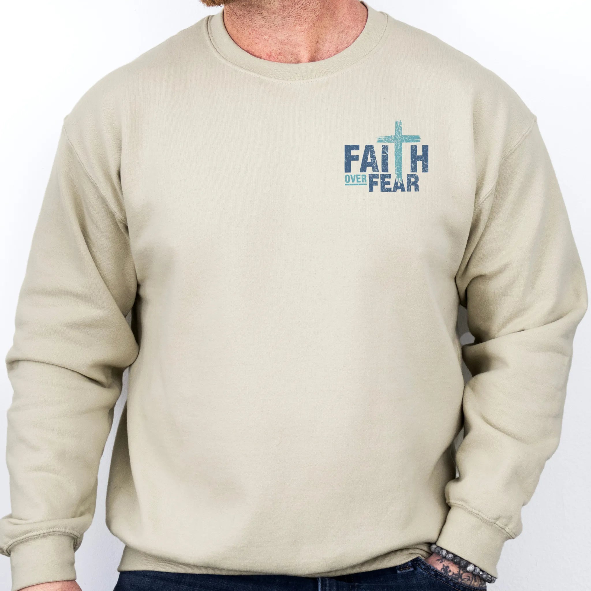 Sand Oakley June sweatshirt, mens fit, left chest badge reads Faith Over Fear with small cross, studio front view