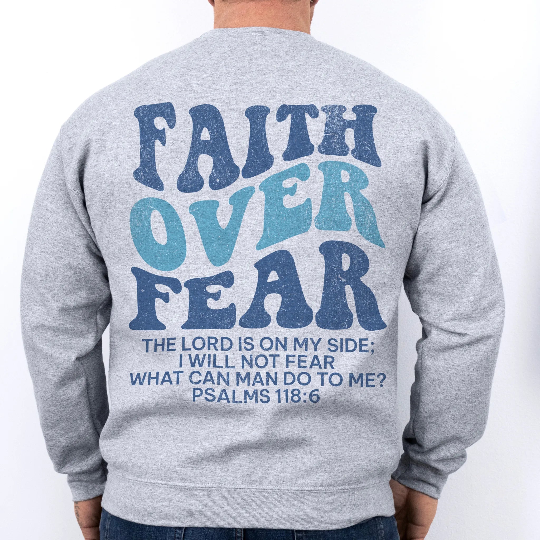 Sport Grey Oakley June sweatshirt, mens fit, large back lettering reads Faith Over Fear with supporting scripture lines, studio back view
