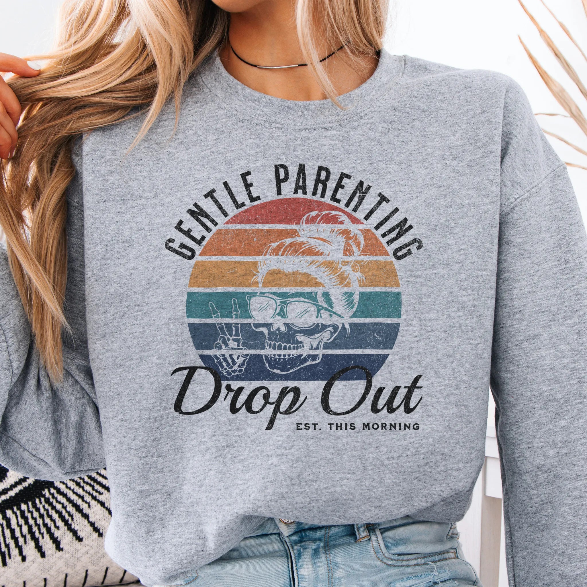 Sport Grey Oakley June Sweatshirt front view Gentle Parenting Drop Out large chest graphic skull with messy bun peace sign round retro stripe badge text Est This Morning distressed print
