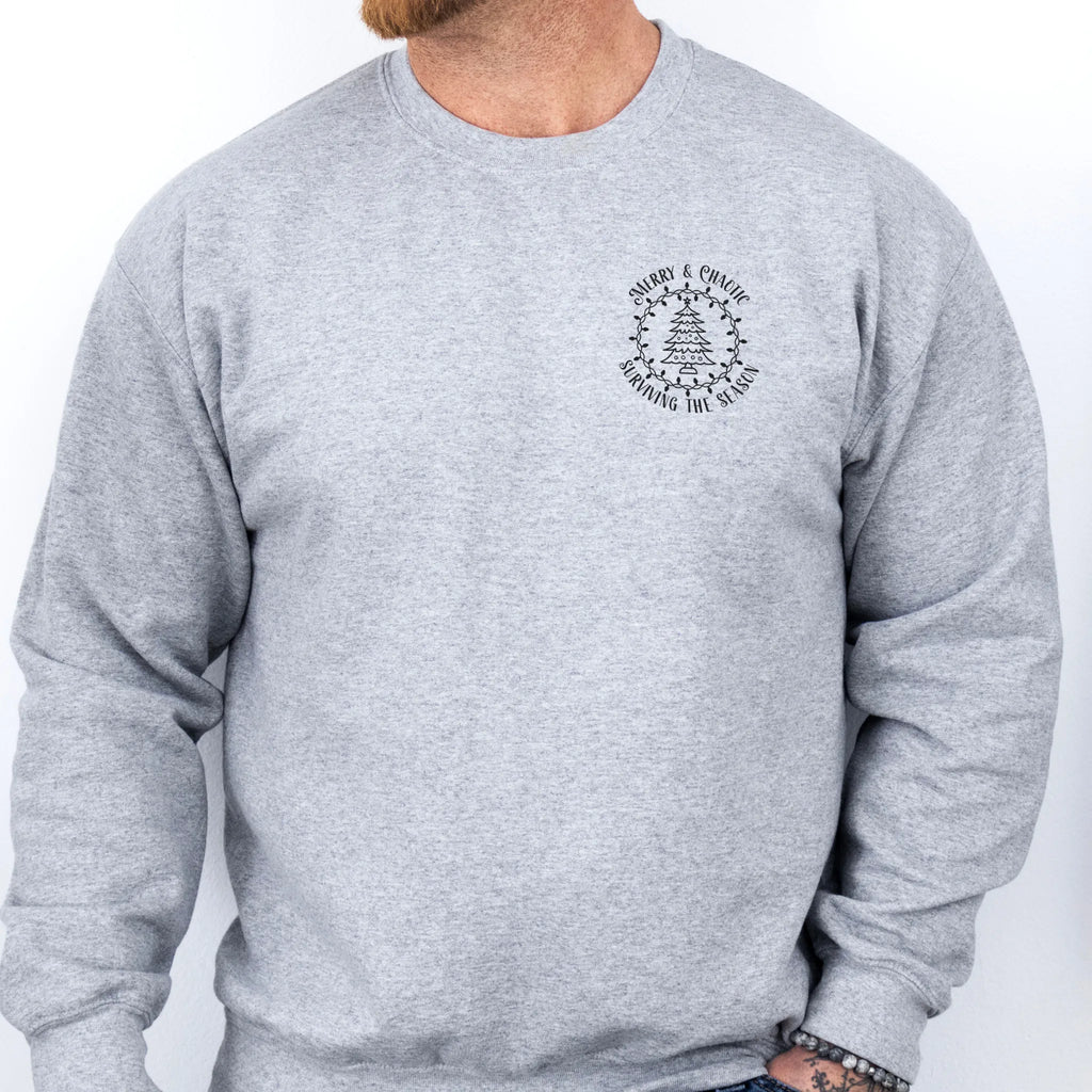 Sport Grey men’s sweatshirt left chest badge text “Merry & Chaotic — Surviving the Season”